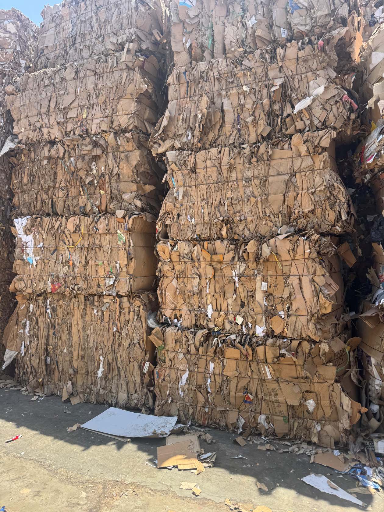 Balles de carton compressé stockées en hauteur dans l'entrepôt